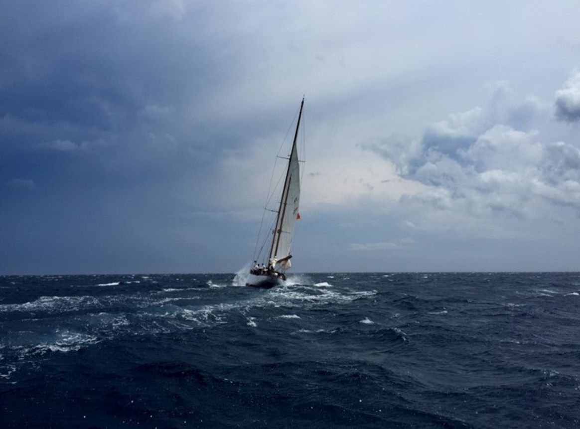 Sailboat in strong winds and cloudy skies